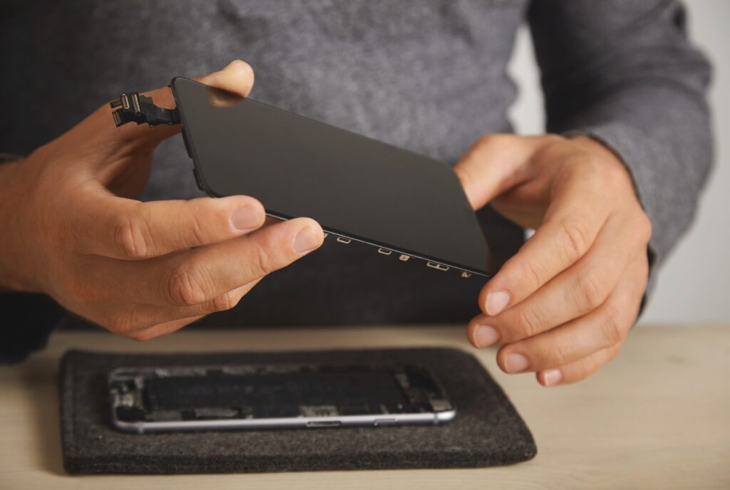 master holds new screen replacement disassembled smartphone his laboratory close up